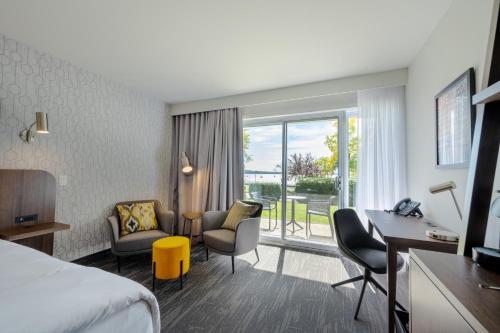 a hotel room with a bed and a desk and chairs at Hôtel Versō in Magog-Orford