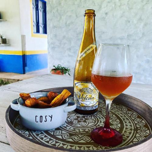 a glass of beer and a bowl of food and a bottle at Finca Cafetera Los Ángeles in Líbano
