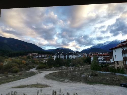 a road in a town with mountains in the background at BANSKO WINSLOW INFINITY - Studio in Bansko