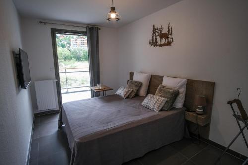 布里昂松SUPERB apt with BALCONY in BRIANÇON的一间卧室设有一张大床和窗户