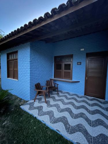 uma casa azul com duas cadeiras e um pátio em Sunshine Inn Centro em Cumbuco