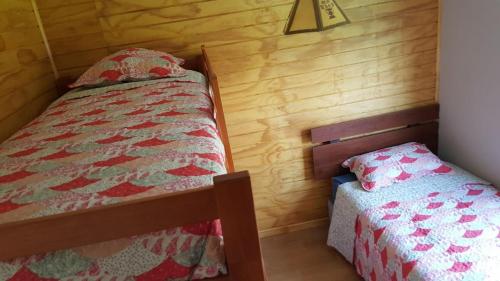 a bedroom with a twin bed and a small bed sidx sidx sidx at CASAS Y CABAÑAS CUMBRES DEL SOL in Castro