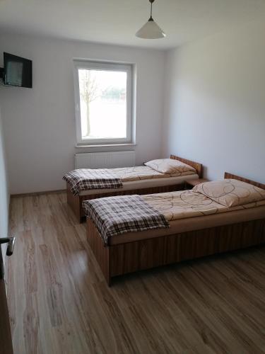 three beds in a room with a window at Tawerna-Stawiska in Garbatka-Letnisko