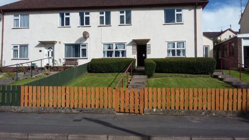 ein weißes Haus mit einem Zaun davor in der Unterkunft Riverview House in Enniskillen