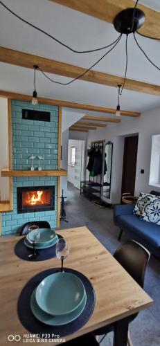 a living room with a wooden table and a fireplace at DWIE DAMY Na Gwizdówce 8 in Załakowo