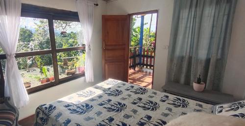 a bedroom with a bed and a large window at Finca Cafetera Los Ángeles in Líbano