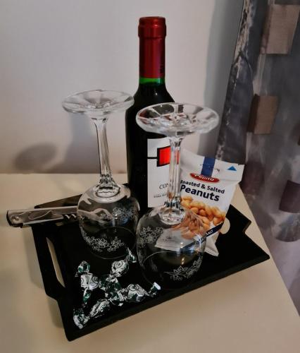 a bottle of wine and two wine glasses on a table at B&B "Villa Alegria", Tarrafal in Tarrafal