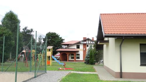 a playground in a yard next to a house at Tawerna-Stawiska in Garbatka-Letnisko