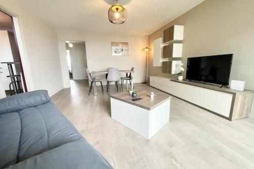 a living room with a couch and a flat screen tv at ROYAL ! Appartement de standing Face à l'océan ! in Ploemeur