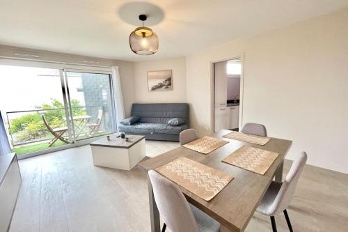 a dining room with a table and a couch at ROYAL ! Appartement de standing Face à l'océan ! in Ploemeur