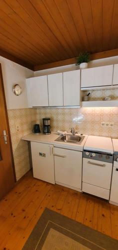 a kitchen with white cabinets and a sink at Henry‘s sweet home in Neukirchen am Großvenediger