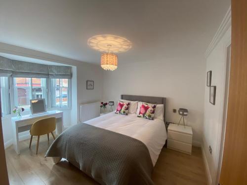 a bedroom with a bed and a desk with a computer at GS - Luxury, modern town centre, 2 beds, free parking for one vehicle in Stratford-upon-Avon