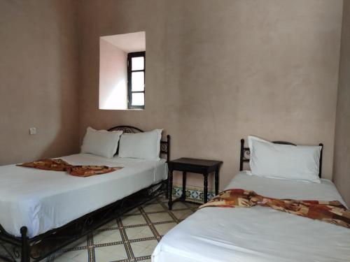 a hotel room with two beds and two lamps at Hotel Zagora in Marrakesh