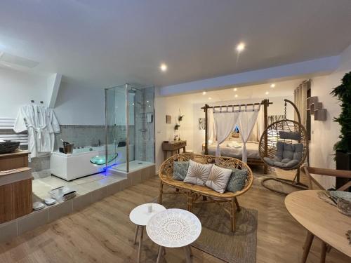 uma sala de estar com mobiliário e um quarto com uma banheira em PARENTHESE LOVE - Bali Mon Amour Suite Balneo SPA Proche Orly-Paris em La Ville-du-Bois