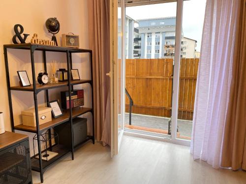 Zimmer mit Bücherregal und großem Fenster in der Unterkunft Wanderlust Home Pink, Rasnov Apt for 4, Wifi and Free Parking in Râșnov