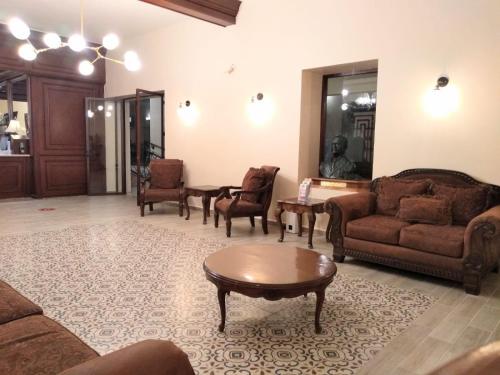 a living room with couches and chairs and a table at Hotel Senorial in Querétaro
