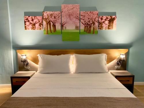 a bedroom with a bed with pink trees painting on the wall at EKA Luxury Two-Bedroom Premium Apartment in Durrës