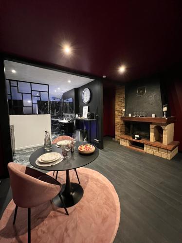 a living room with a table and chairs and a fireplace at PARENTHESE LOVE - Amour & Tentation Suite Balnéo SPA Proche Orly-Paris in La Ville-du-Bois