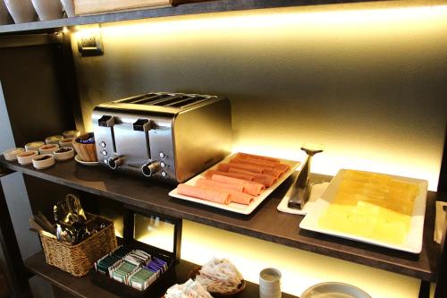 a counter with a toaster and a plate of food at Soltigua Apart Hotel Mendoza in Mendoza