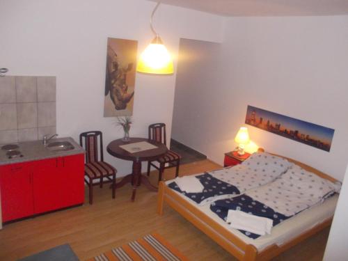 a bedroom with a bed and a table and chairs at Apartments Agape in Belgrade