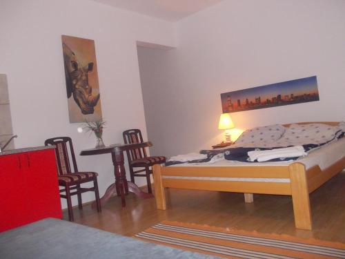 a bedroom with a bed and a table and chairs at Apartments Agape in Belgrade