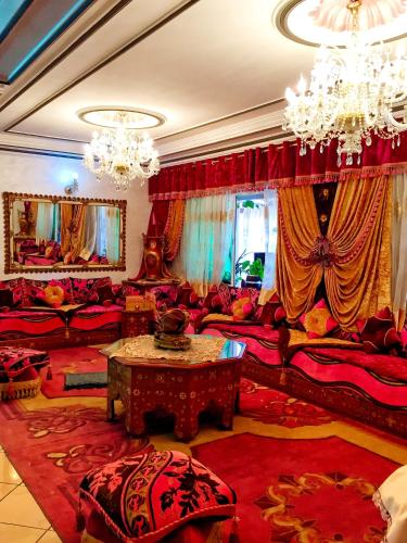 a living room with red furniture and a chandelier at cozy apartment city center near the sea playa wifi!! in Tangier