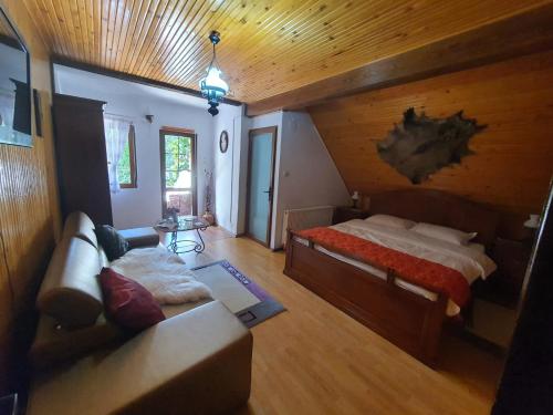 a bedroom with a bed and a couch in a room at Casa Serban in Durau