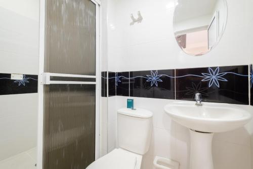 Ayenda Victoria Comfort في بوكارامانغا: حمام به مرحاض أبيض ومغسلة