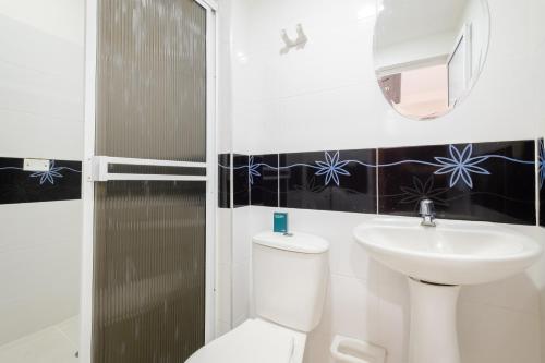 a bathroom with a white toilet and a sink at Hotel Victoria Comfort in Bucaramanga