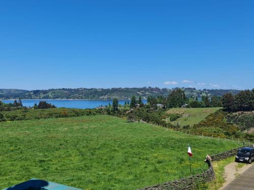 a car parked in a field next to a lake at CASAS Y CABAÑAS CUMBRES DEL SOL in Castro