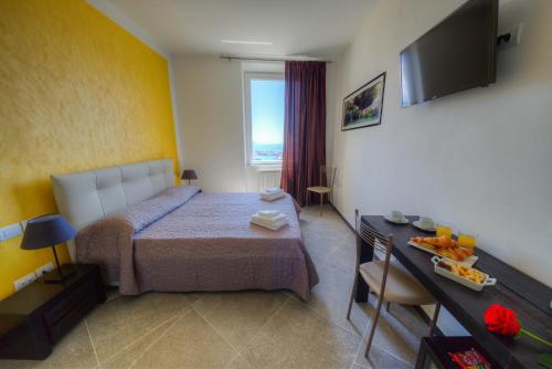 a bedroom with a bed and a table and a television at 88 Miglia in La Spezia