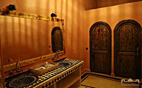 a bathroom with a sink and a large mirror at Sunrise Palace Merzouga in Merzouga