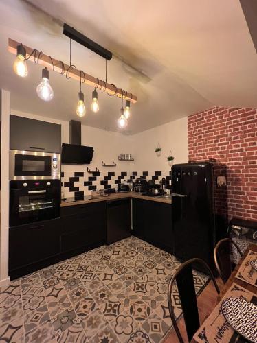 - une cuisine avec du carrelage noir et blanc sur le mur dans l'établissement BEAU T3 STYLE INDUSTRIEL N20 ORLY PARIS WIFI Underground Industry, à La Ville-du-Bois