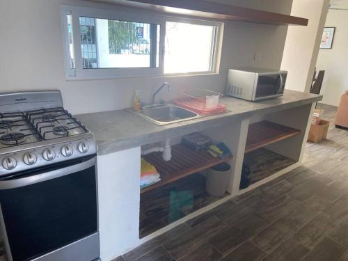 a kitchen with a stove and a sink at Casa de verano totalmente equipada y amueblada in Santa Cruz Huatulco