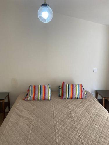 a bedroom with a bed with two pillows on it at Casa de verano totalmente equipada y amueblada in Santa Cruz Huatulco
