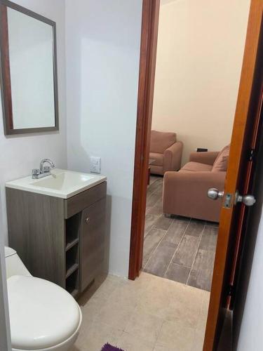 a bathroom with a toilet and a sink and a couch at Casa de verano totalmente equipada y amueblada in Santa Cruz Huatulco