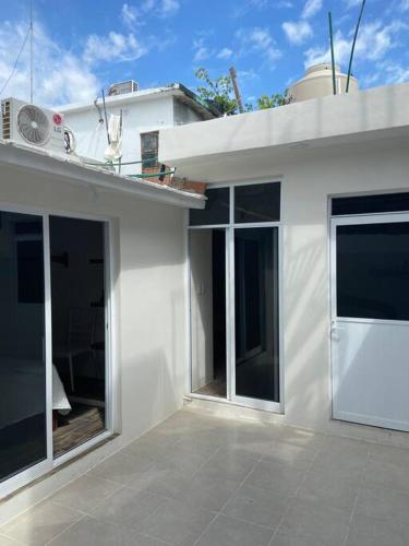 a white house with large windows and a balcony at Casa de verano totalmente equipada y amueblada in Santa Cruz Huatulco