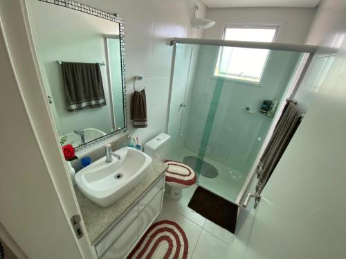 a bathroom with a sink and a glass shower at Solar de Palmas - Apt 208 in Governador Celso Ramos