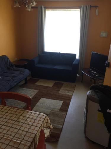 a living room with a blue couch and a window at CASAS Y CABAÑAS CUMBRES DEL SOL in Castro