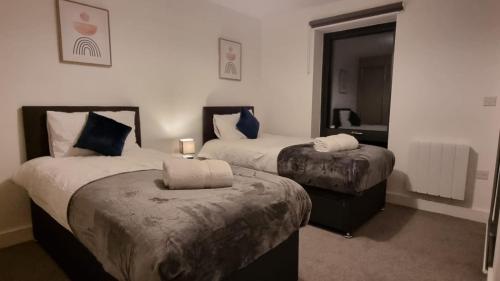 a hotel room with two beds and a mirror at B90 Contractor & Family Stays Near NEC BHM Airport in Hockley Heath