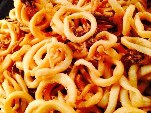 a pile of spaghetti with meat and cheese at Hostal ROM Familiar in Roses
