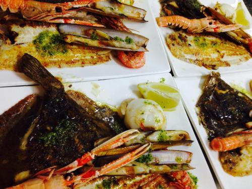 a plate of food with seafood and other foods at Hostal ROM Familiar in Roses