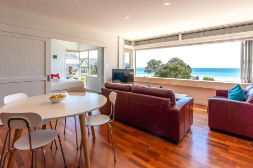 a living room with a couch and a table at The Sands - Apartment 26 - Stay Waiheke in Onetangi