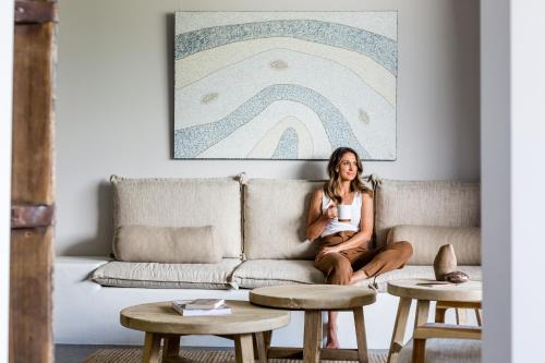 a woman sitting on a couch in a living room at Imperial Boutique Accommodation in Eumundi