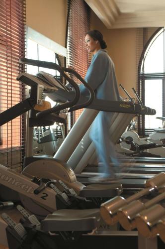 a woman running on a treadmill in a gym at Shangri-La Qaryat Al Beri, Abu Dhabi in Abu Dhabi