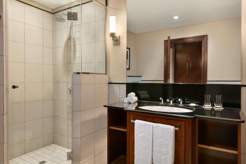 a bathroom with a sink and a shower at Shangri-La Qaryat Al Beri, Abu Dhabi in Abu Dhabi