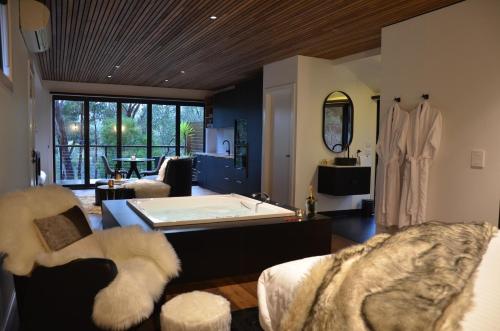 a large room with a bath tub and a living room at Kudos Villas - Hepburn Springs in Hepburn Springs