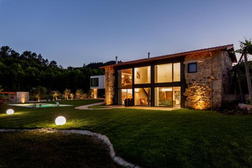 a stone house with two lights on the lawn at Casas Casal de Nino in Celorico de Basto