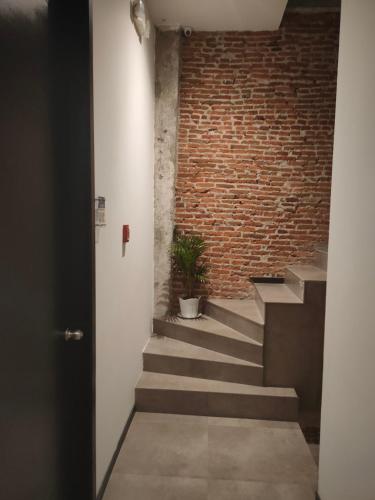 a brick wall and stairs with a potted plant at HOTEL BOUTIQUE PANAMÁ in Guayaquil