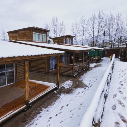 a log cabin in the snow with snow covered ground at Mirador de Montaña in Ciudad Lujan de Cuyo